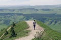 Lonely man walks along a mountain road into the distance