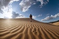 Lonely man walks in desert dunes Royalty Free Stock Photo