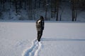 A lonely man walks in the snow. Dramatic silhouette of a man walking in a snowy clearing in the forest. Coldly