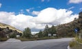 Lonely and moody road with clouds and an interesting light. Mountain road with dramatic colourful sky. Journey, outdoor, travel