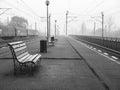 Lonely moody scene with a train station or railway platform on a foggy morning