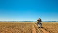 One Motorbiker driving on dirt road through grasland desert. Motorcycle Adventure in Namib, Namibia.