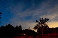 Evening landscape: a starry sky in the clouds and a comet over a willage after sunset. Royalty Free Stock Photo