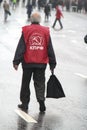 The lonely old man the pensioner with a bag in hands, in day of procession of communists