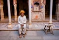 Lonely old man sitting inside an vintage indian house