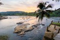 Lonely palm tree with wide angle rocky river sunset landscape with jungle banks in Pinnawala Elephant Orphanage Royalty Free Stock Photo