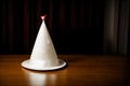 A lonely party hat left behind on a candlelit table