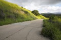 Walking on a lonely paved hiking road passing through the hills 