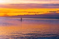 Lonely person silhouette standing on paddle board at sunset. Royalty Free Stock Photo