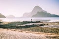 Lonely photographer on top of the rocks during low tide making photo on morning sunrise light in front of amazing Cadlao