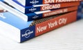 The Lonely Planet logo on the back of a series of stacked travel guide books. Famous Australian brand of tour guides. Illustrative Royalty Free Stock Photo