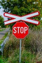 Lonely railway stop sign with cross in the day light Royalty Free Stock Photo