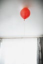 Lonely red balloon hanging from the ceiling