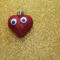 Lonely red heart with big eyes on the golden background shiny