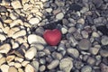 Lonely red heart with drops of water lies on a stone beach, concept of loneliness, concept of love. Symbol of love and family. Royalty Free Stock Photo