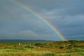 Lonely road through beautiful icelandic green rural landscape after rain weather change with colorful rainbow - Iceland Royalty Free Stock Photo