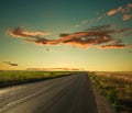 Lonely road leading to the horizon at sunset sky Royalty Free Stock Photo