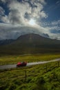 Lonely road and red car with colorful autumn grass land and mountain, Isle of Skye, Scotland, UK, Royalty Free Stock Photo