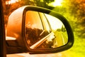 Lonely road seen through rear side mirror. Sky and trees landscape Reflect in Mirror of Car During the Car Moving concept. Travel Royalty Free Stock Photo