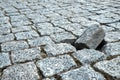 Lonely rock on a damaged cobblestone street in an old medieval city. Paved boulevard made of stones. Urban footpath mosaic from