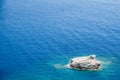 Lonely rock surrounded by blue sea Royalty Free Stock Photo
