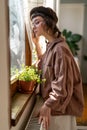 Lonely sad hipster girl looking out window while spending time at home Royalty Free Stock Photo