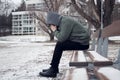 Lonely and sad man sitting on a park bench in snowy winter scenery Royalty Free Stock Photo