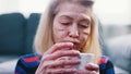 Lonely sad old woman drinking hot beverage. Mental health and loneliness concept