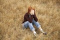 Lonely sad red-haired girl at field