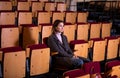 Lonely sad woman sitting in empty audience hall