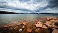 Lonely sail boat in archipelago. ramatic sky over stony beach coast and shallow water. Storsand, High Coast in northern Sweden