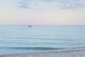 Lonely sailboat in the open sea at sunset. Royalty Free Stock Photo