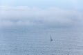 Lonely sailboat sailing the vast ocean.