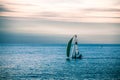 A lonely sailboat in the sea at the end of the day.