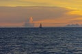 Lonely sailboat in the sea with orange sky Royalty Free Stock Photo