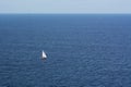 A lonely sailing boat against the blue sea.