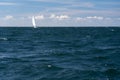 Lonely Sailing boat on blue open sea. Concept of loneliness, solitude and desolation