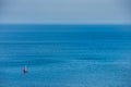 A lonely sailing boat crossing a blue, calm ocean near Mons Klint as the equipage enjoys a relaxing escape away in the Baltic sea