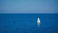 A lonely sailing boat dances on the canvas of clear blue waters, a symphony of maritime solitude