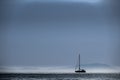 Lonely sailing boat in the early morning hours in front of an island. Dreamy Boat Trips, Discover Greece by Sea