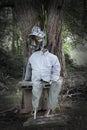 Lonely scarecrow sits under tree shade in the dark Royalty Free Stock Photo