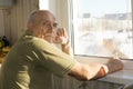 Lonely senior man sitting at a window Royalty Free Stock Photo