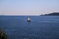 Lonely ship, sailboat at open sea. Calm sea allows best sailing in peaceful scene. Little sailing boat on turquoise sea.