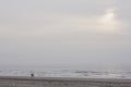 Silhouettes of two people walking along the cold winter shore of the north sea at sunset