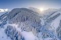 lonely single hut in forest clearing in snowy austrian mountains in winter with sunbeams