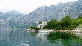 Lonely small boat in a fisherman village in the bay of Kotor. Lake surrounded by grey big mountains and green brushes. Landscape Royalty Free Stock Photo