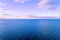 Lonely small boat in the vast ocean at dusk.