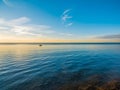 Small fishing boat floating on shallow water at dusk. Royalty Free Stock Photo