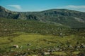 Lonely small house on green fields and rocky landscape Royalty Free Stock Photo