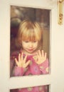 Sorrowful child stand at door window